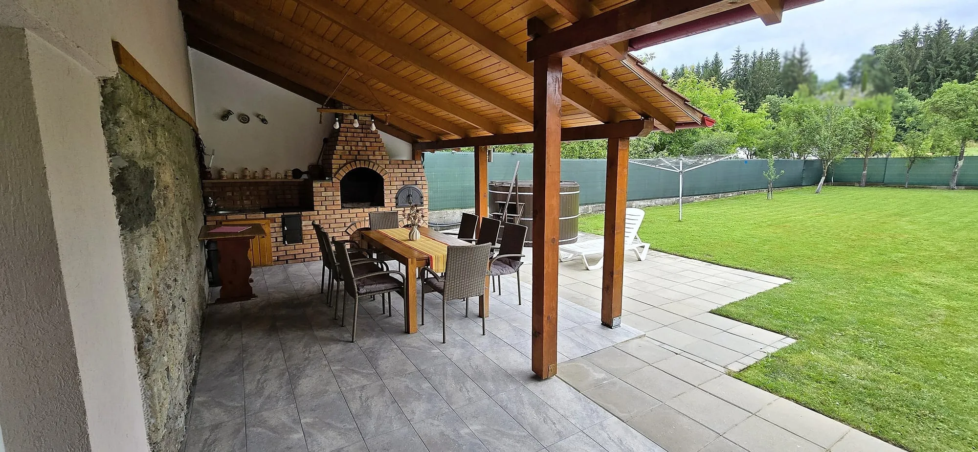 Covered terrace of Casa Korona guesthouse with hot tub and garden